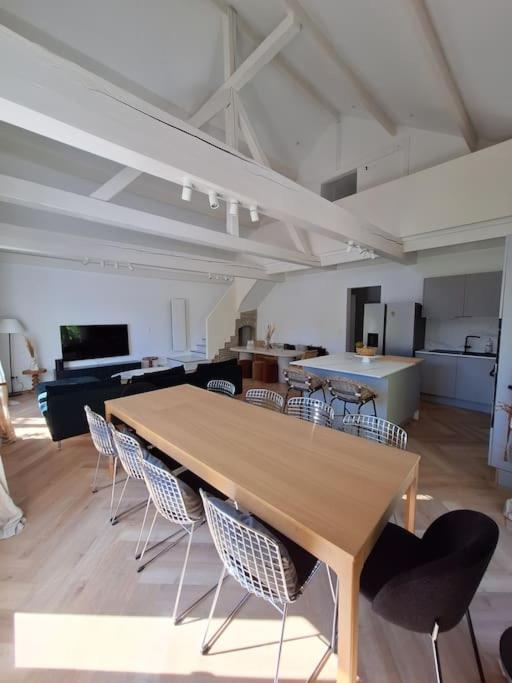 Cette grande chambre dispose d'une table et de chaises en bois. dans l'établissement Grande maison élégante, à Argenteuil
