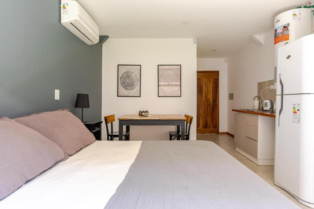 a bedroom with a bed and a table and a refrigerator at The Lodge Chacras in Ciudad Lujan de Cuyo