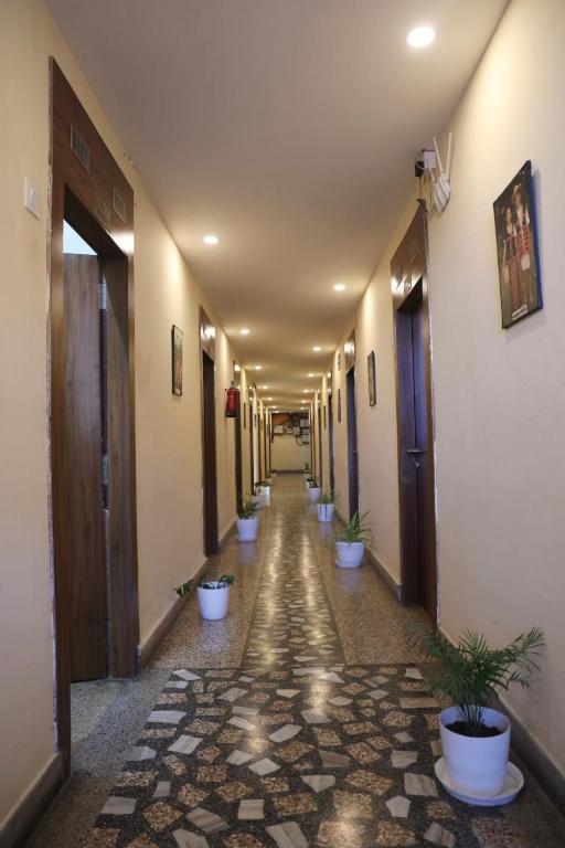 a hallway with a row of potted plants at Hotel Embassy in Dibrugarh