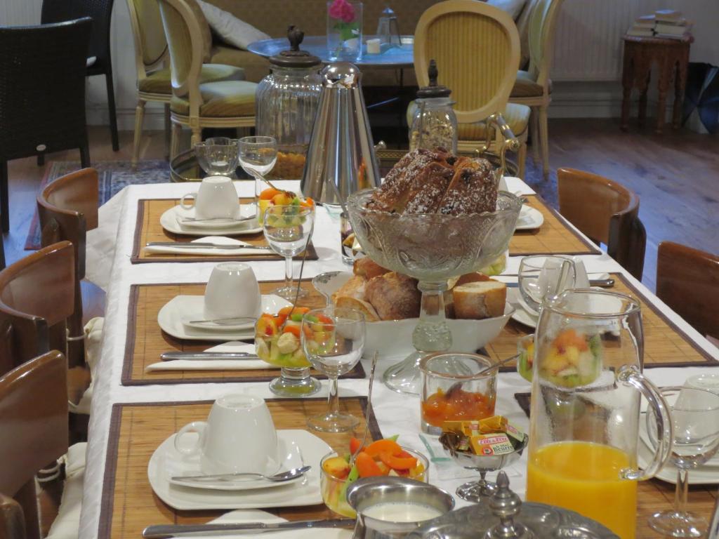 una mesa con comida y copas de vino. en La Maison des Fontaines d'Alsace, en Ferrette