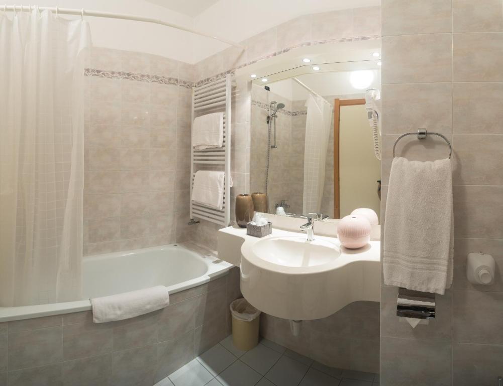 y baño con bañera, lavamanos y bañera. en Roero Park Hotel, en Sommariva Perno