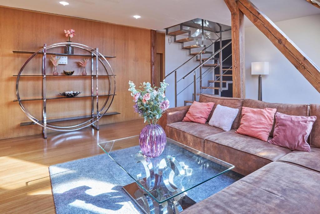 a living room with a couch and a glass table at Žatecká - Terrace Residence in the Old Town in Prague