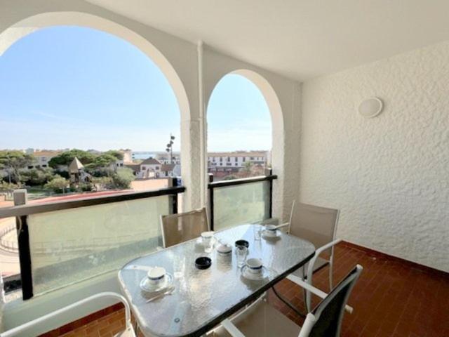 une salle à manger avec une table et une grande fenêtre dans l'établissement Agréable appartement pour 4 personnes avec piscine collective 4MAR207, au Barcarès