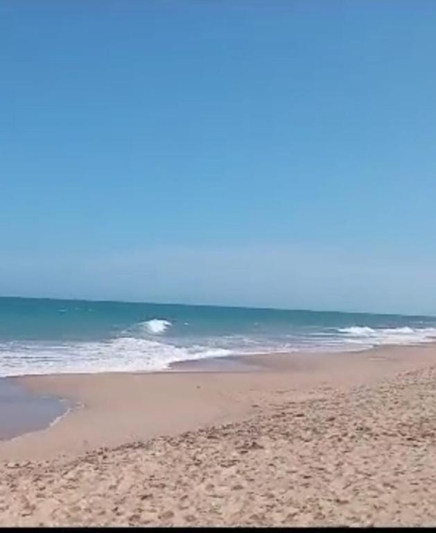 a sandy beach with the ocean in the background at Casa Marataízes in Marataizes