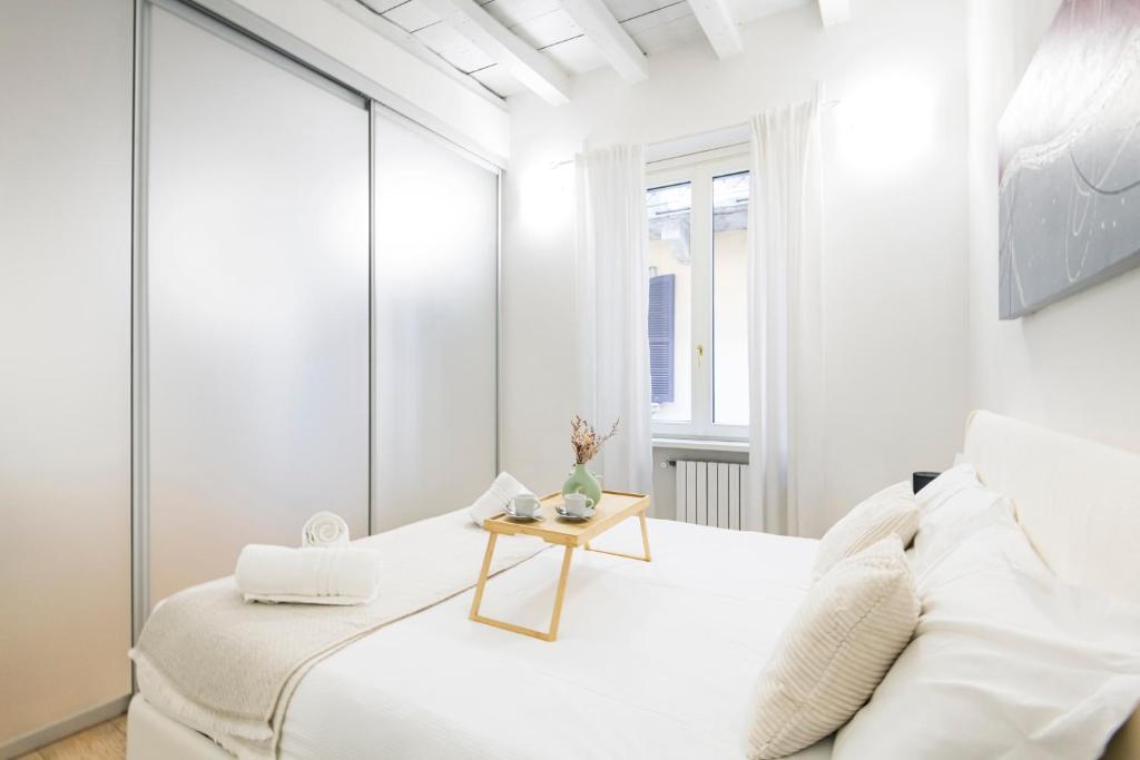 biała sypialnia z białym łóżkiem i stołem w obiekcie Amazing, new & fully furnished studio in Duomo w Mediolanie