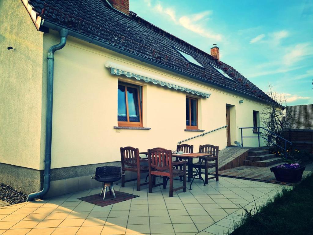 a patio with a table and chairs on a house at Ferienhaus am Pferdehof in Schapow