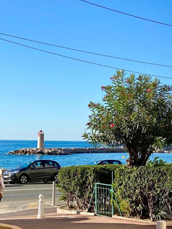 une voiture garée près de l'océan avec un phare dans l'établissement Château Saint Louis - Menton, à Menton