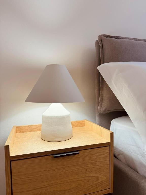 a lamp on a night stand next to a bed at Casa Magenta Holiday in Galatro