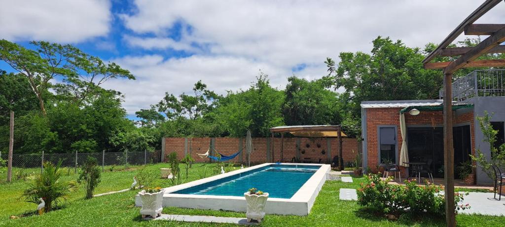 Una piscina en un patio con un columpio. en Posada LA MARRU, en Paraguarí