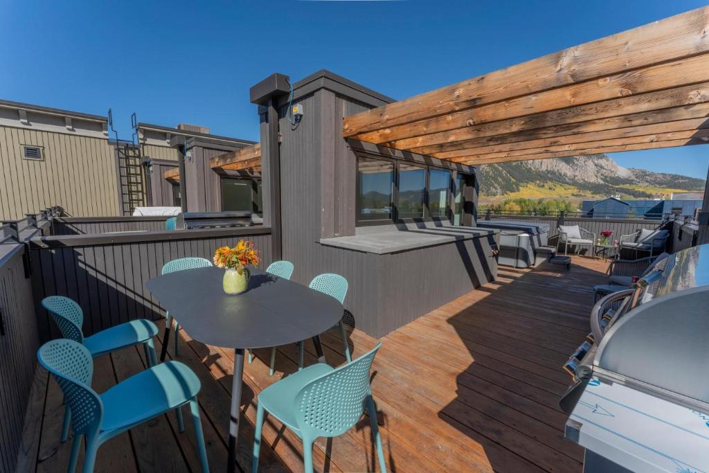 a patio with a table and chairs on a deck at Academy Place | Wild Iris in Crested Butte