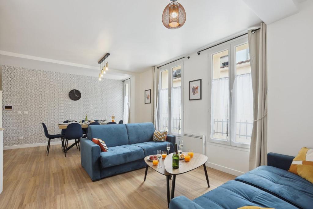 un salon avec un canapé bleu et une table dans l'établissement 865 Suite Jasmin - Superbe appartement, à Montreuil