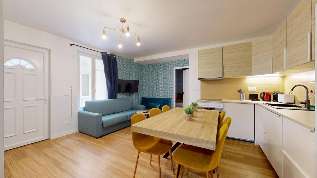 une cuisine et une salle à manger avec une table et des chaises dans l'établissement 864 Suite Iris - Superbe appartement, à Montreuil