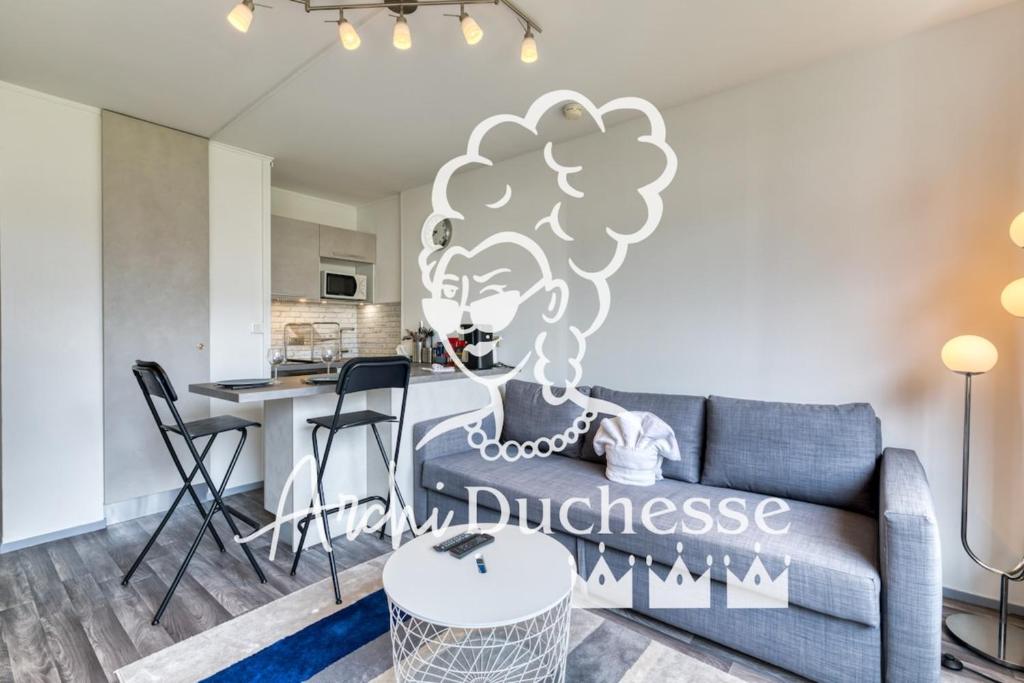 un salon avec un canapé et une cuisine dans l'établissement Olivia studio avec Place de Parking, à Rouen