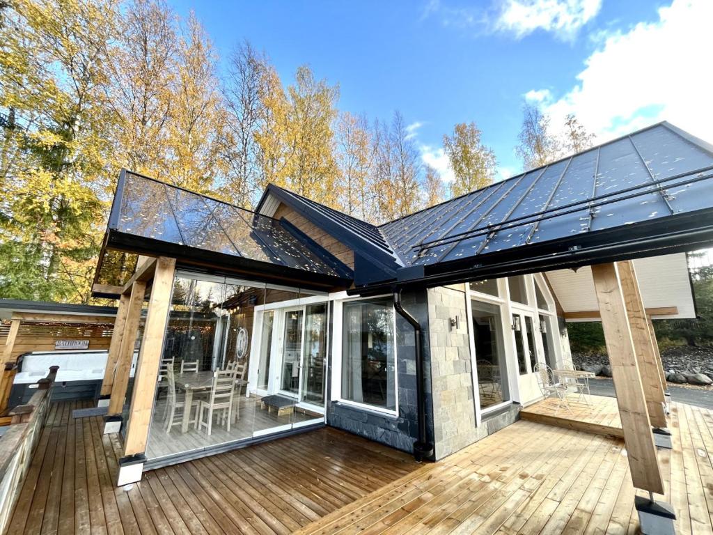 a house with a glass roof on a wooden deck at Rantavilla 7 hlo poreallas in Jämsä