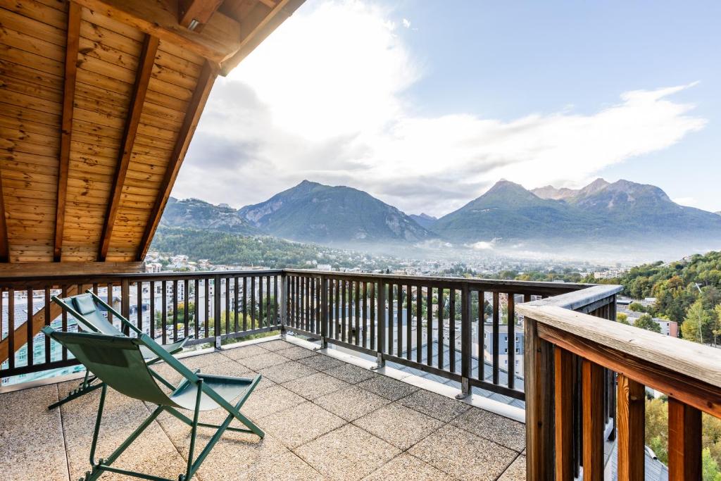 a chair on a balcony with a view of mountains at Les 5 Vallées - Appt en Duplex avec vue montagne in Briançon