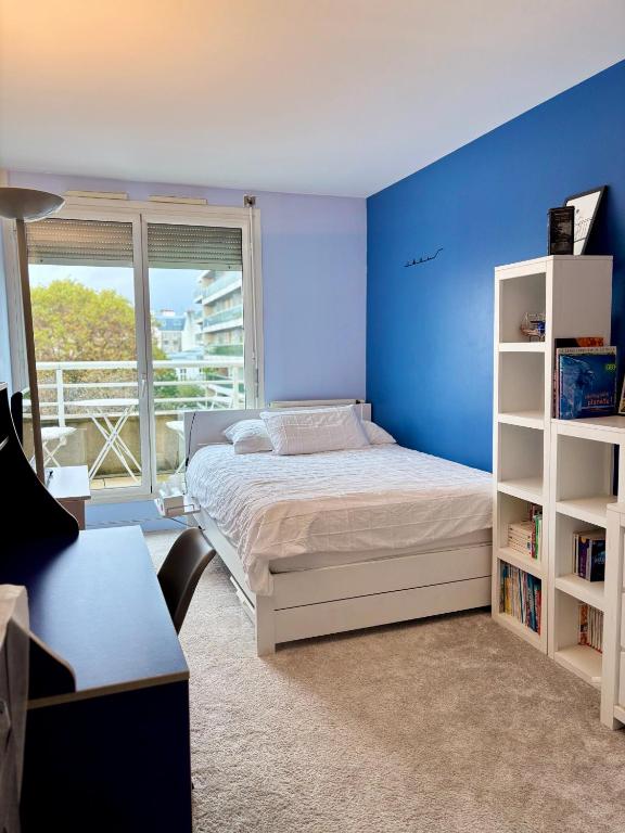 une chambre avec un lit et un mur bleu dans l'établissement Chambre calme et lumineuse en plein coeur de Paris, à Paris