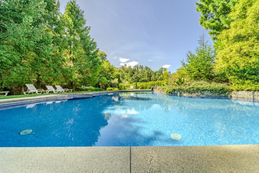 una piscina con acqua blu in un cortile di Ge House by House and People a Caniçada