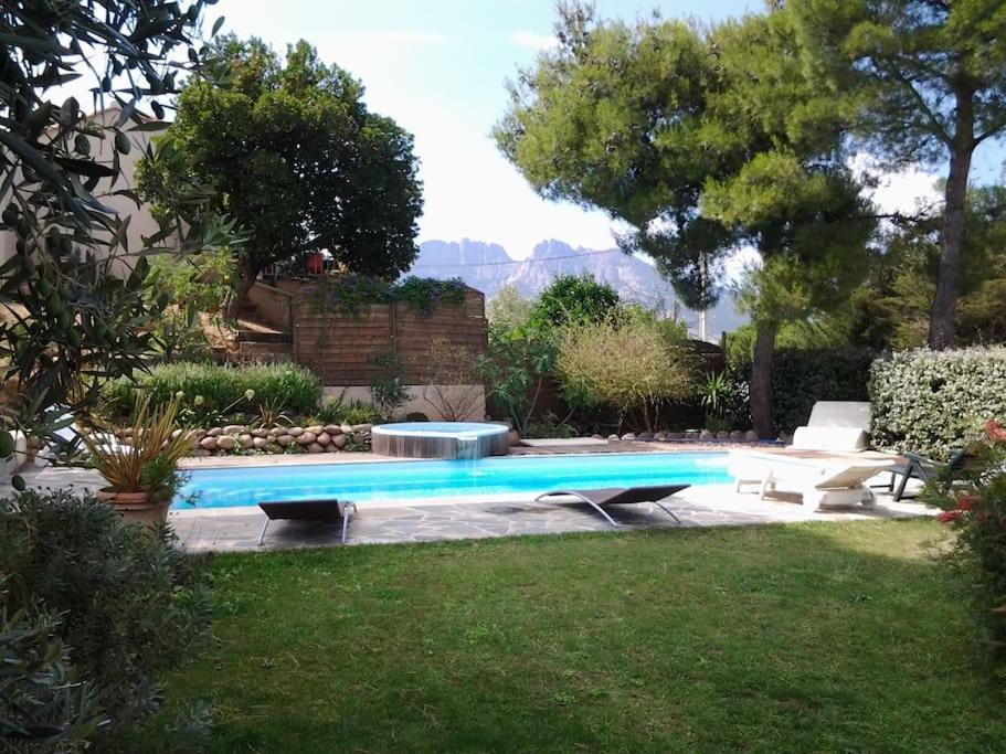 - une piscine dans un jardin avec une table et des chaises dans l'établissement Appartement climatisé, 4 personnes, proche Calvi, à Calenzana