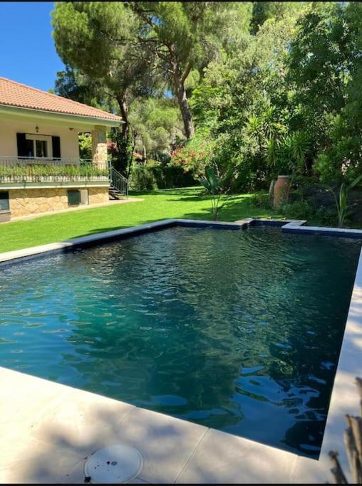 a swimming pool in front of a house at Vivienda Pantano de San Juan in San Martín de Valdeiglesias