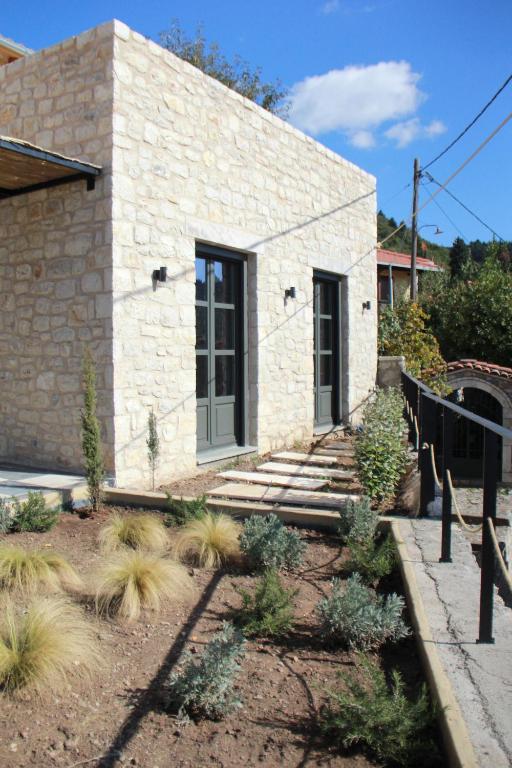 a stone house with a staircase leading to a door at Lithero Suites in Stemnitsa