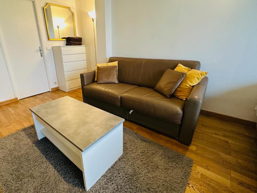 - un salon avec un canapé brun et une table basse dans l'établissement Montparnasse Duroc Paris, à Paris