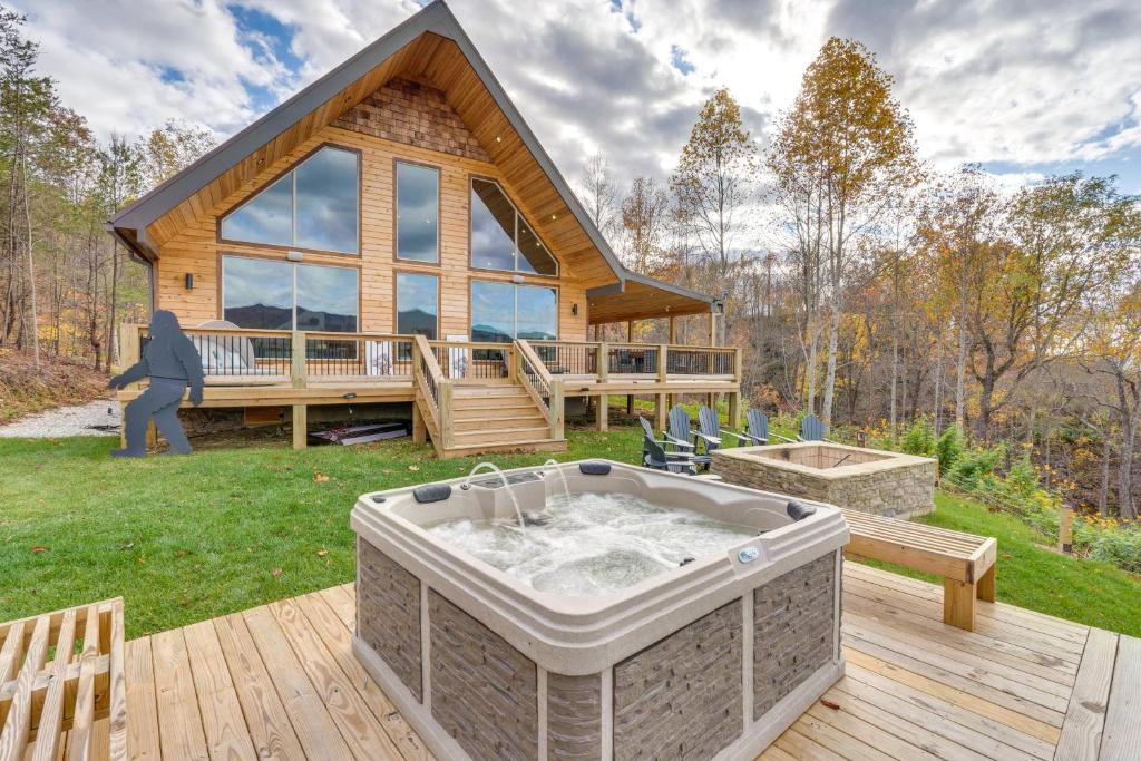 a log cabin with a hot tub on a deck at Nantahala Forest Cabin with Fire Pits and Hot Tub! in Andrews