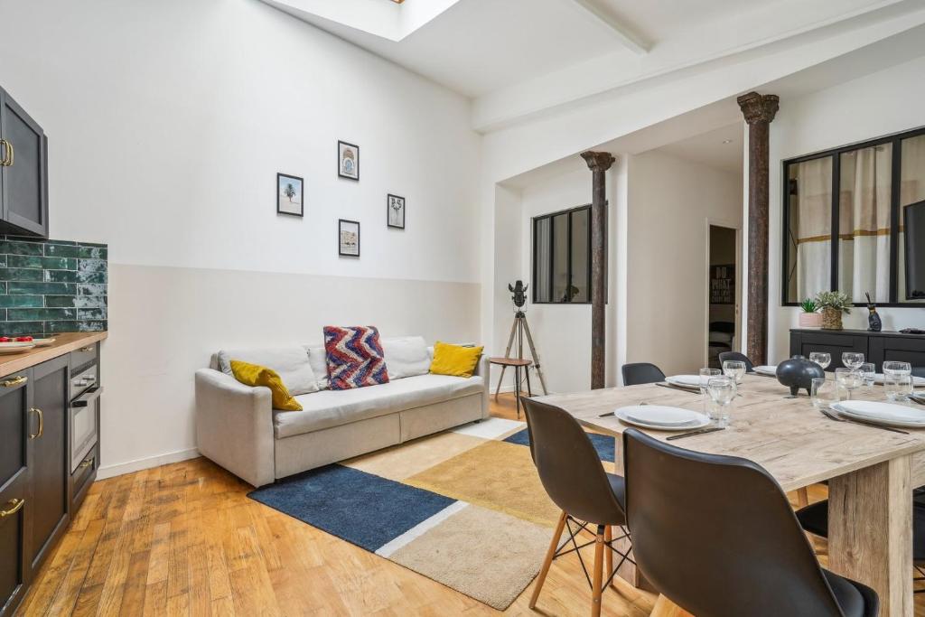 un salon avec une table et un canapé dans l'établissement 205-Suite Villa Valmy, à Paris