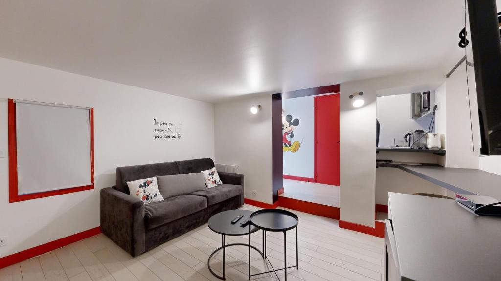 un salon avec un canapé et deux tables dans l'établissement 229 Suite Fantasyland - Superb apartment, à Paris
