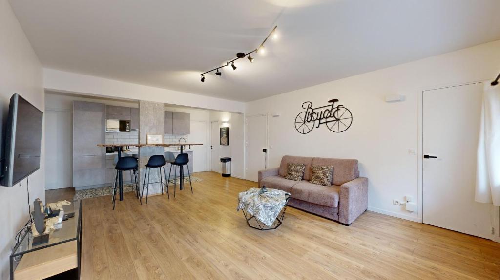 een woonkamer met een bank en een fiets aan de muur bij 199 Suite Monopoly - Superb Apartment in Paris in Parijs