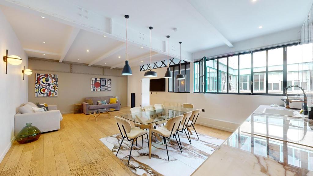 un salon avec une table en verre et des chaises dans l'établissement 178 Suite Cesar - Superb apartment in Paris, à Paris