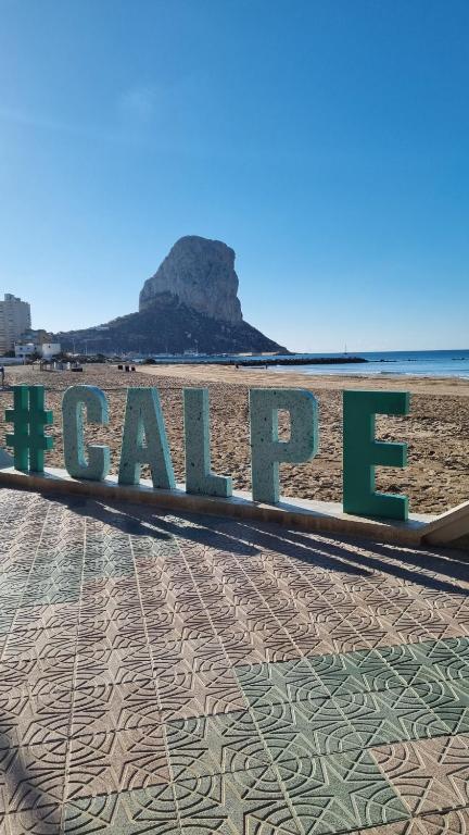 a sign on the beach with a view of the ocean at Ap Skerup Calpe City cerca Playa in Calpe