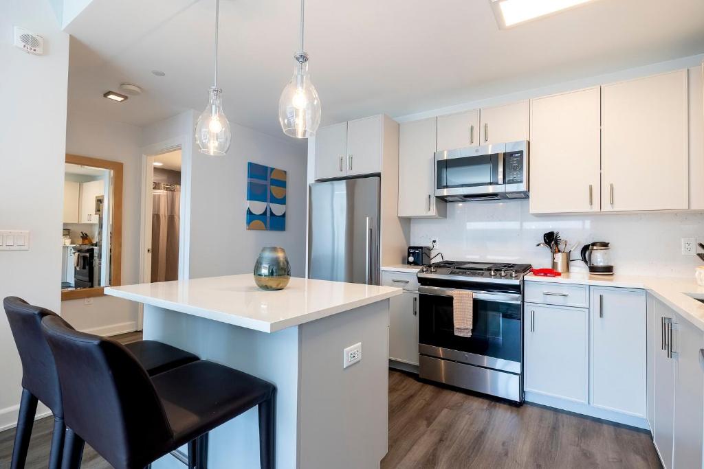a kitchen with white cabinets and a counter top at Luxury Apt with Gym & Pool in Stamford