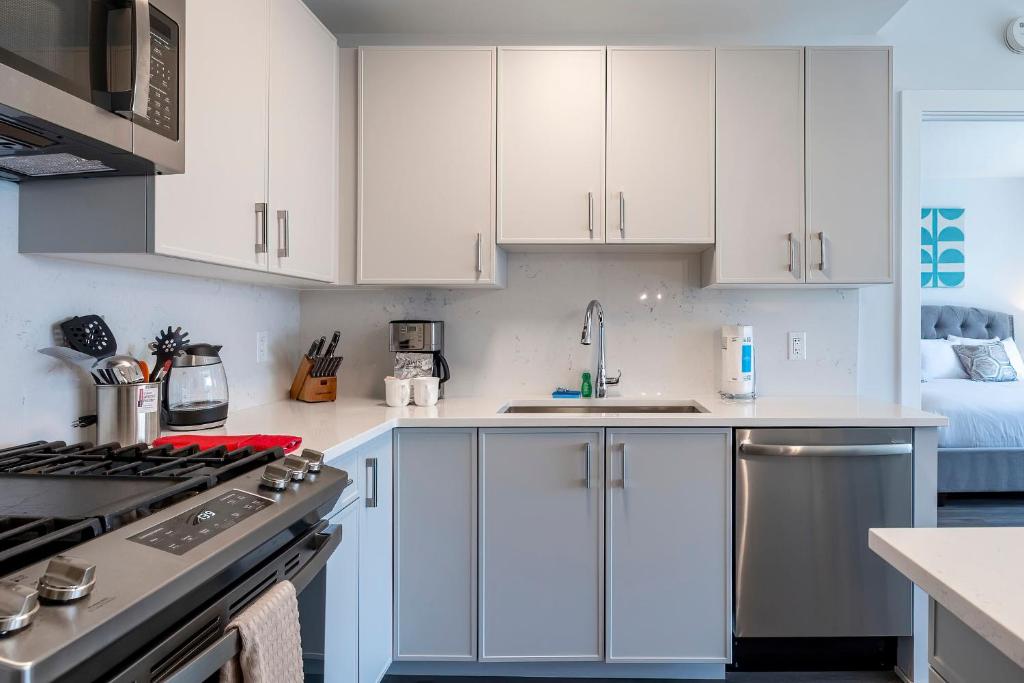 a kitchen with white cabinets and a stove top oven at Luxury Apt with Gym & Pool in Stamford