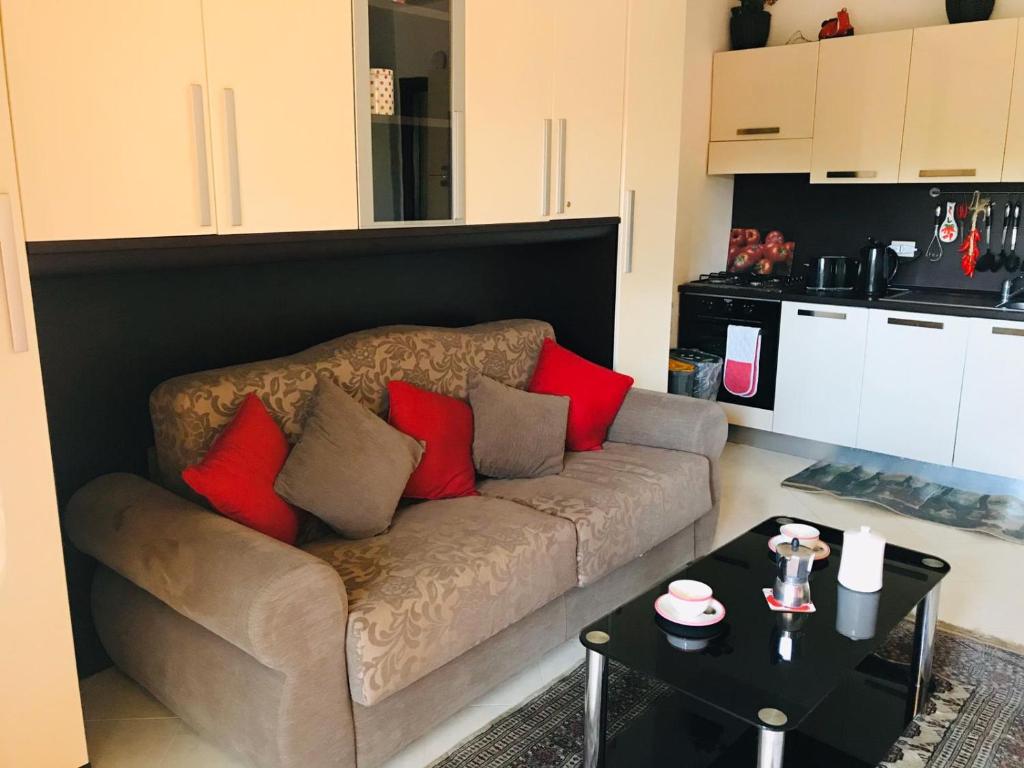 sala de estar con sofá y almohadas rojas en Pizzo Beach Studio 121G, en Pizzo