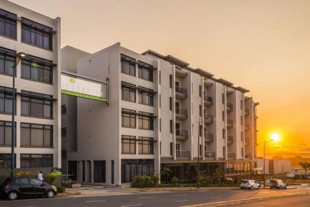 a large white building with cars parked in front of it at K010 Urban Park, Umhlanga Ridge, 1 bedroom apartment in Durban