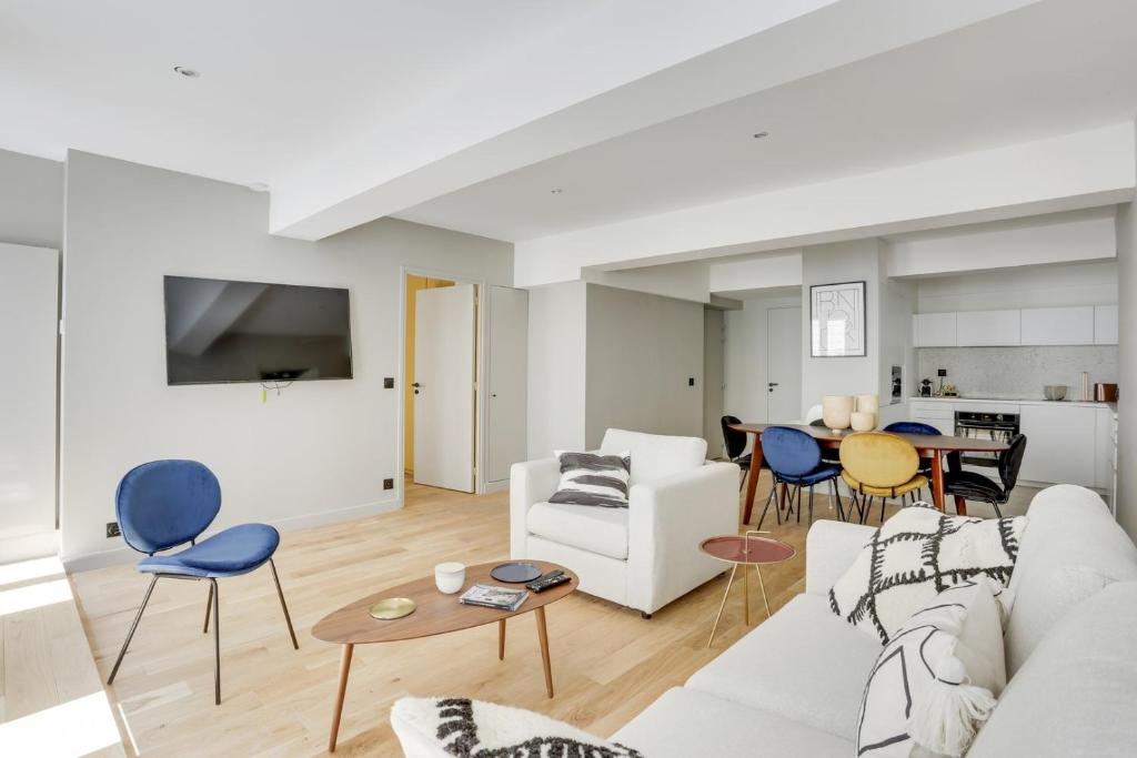 - un salon avec un canapé blanc et des fauteuils bleus dans l'établissement 169 Suite W - Élégant Appartement à Paris, à Paris