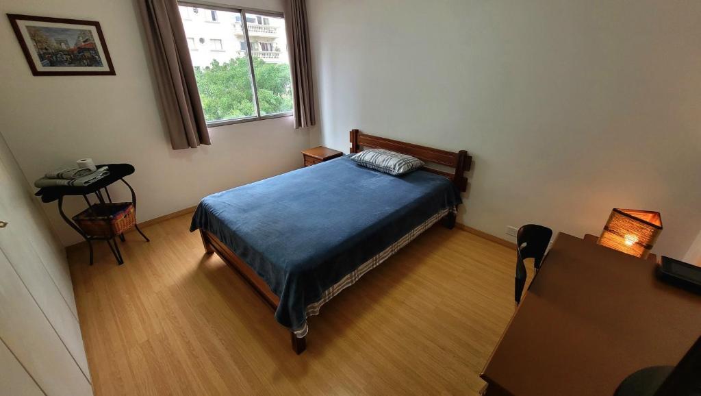 a small bedroom with a bed and a window at Quarto e banheiro privativos no Jardins in São Paulo