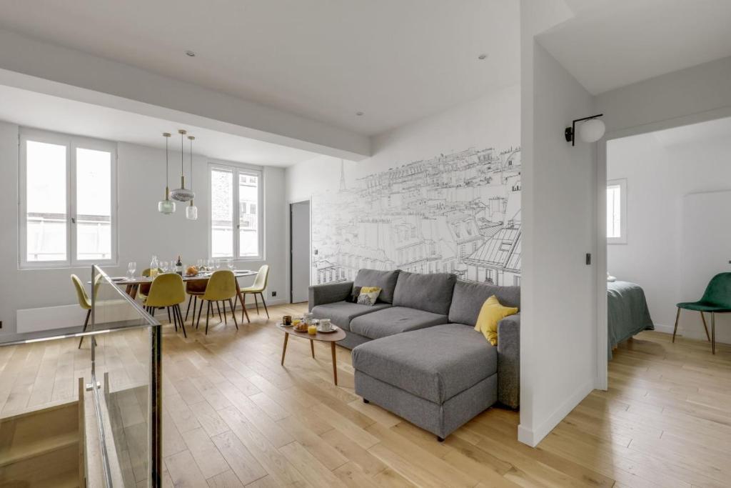 un salon avec un canapé et une salle à manger dans l'établissement 168 Suite M - Superbe Appartement à Paris, à Paris