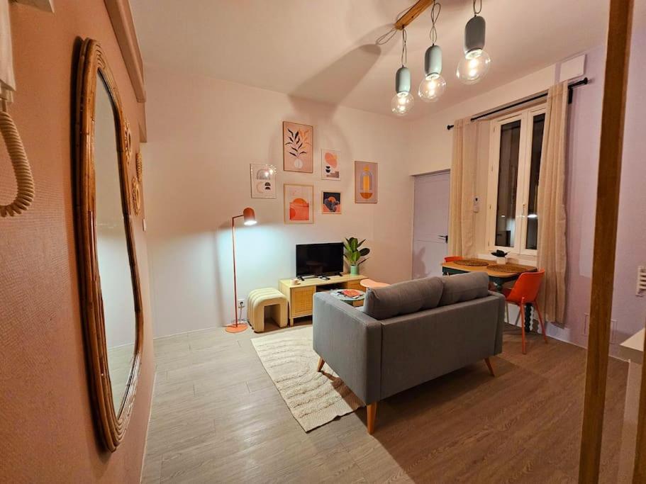 un salon avec un canapé et une table dans l'établissement Le Pastel YourHostHelper, à Narbonne