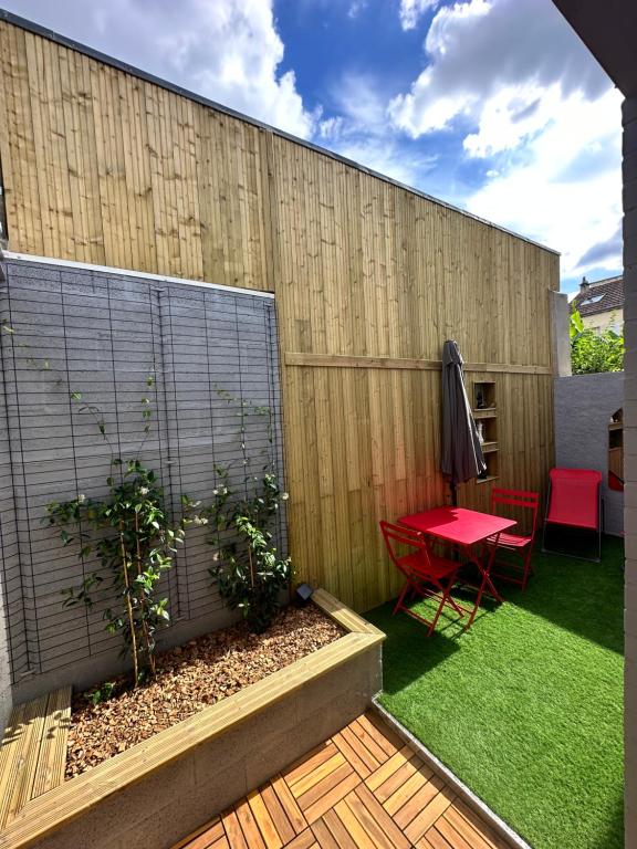 une terrasse avec une table rouge et une clôture dans l'établissement LE Cosy 155 Climatisé, à Tours