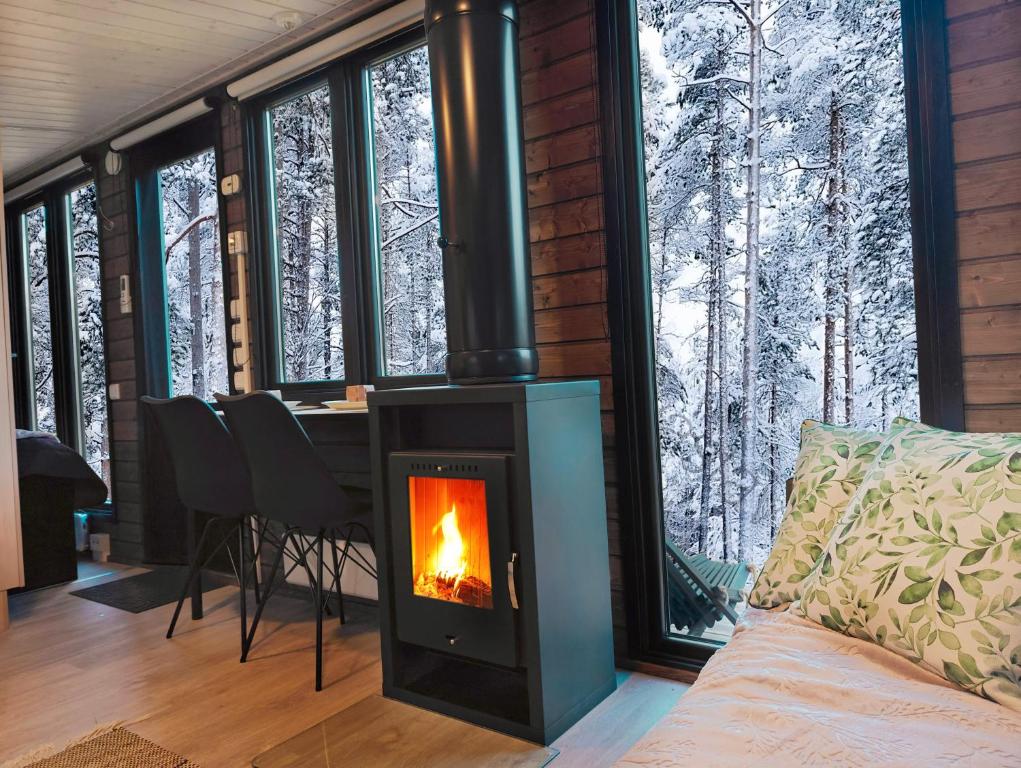 アカスロンポロにあるLapland Riverside Cabin 4 HILLA , Ylläs, Tiny Home with Sauna, Fireplace, Terrace, BBQ, Wifi, Ski, Fishing, Pets OKの暖炉付きのリビングルーム(ログキャビン内)