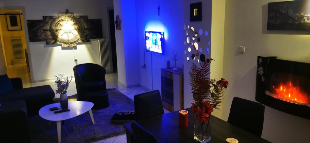 a living room with a fireplace and a blue light at Black & White Apartment ! in Tríkala