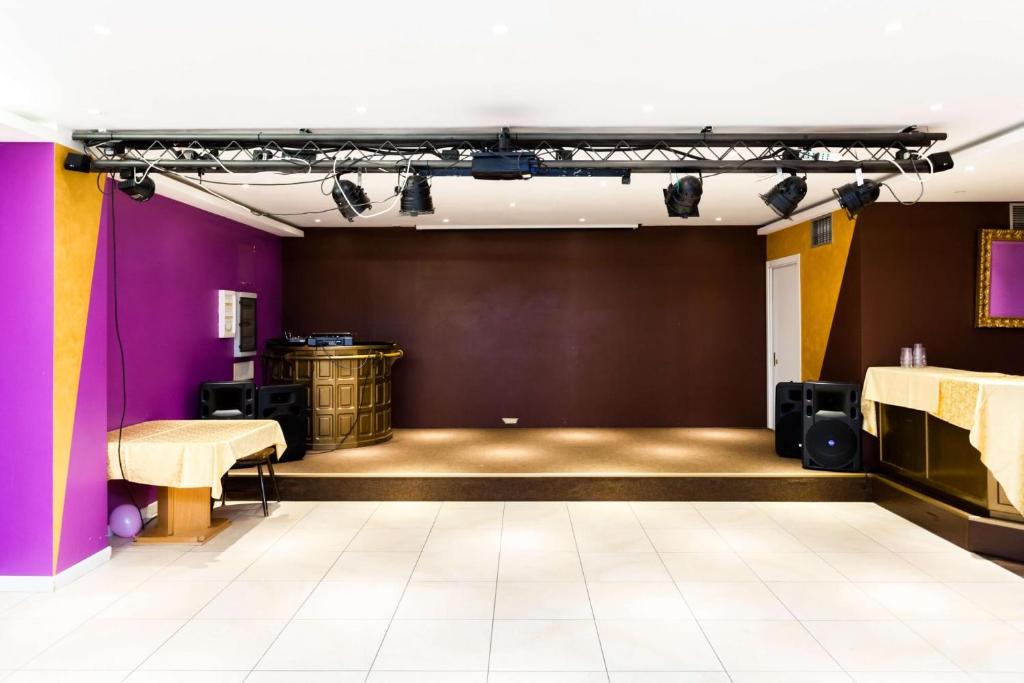 an empty room with a stage with purple walls at Hotel Vienna in San Martino di Castrozza