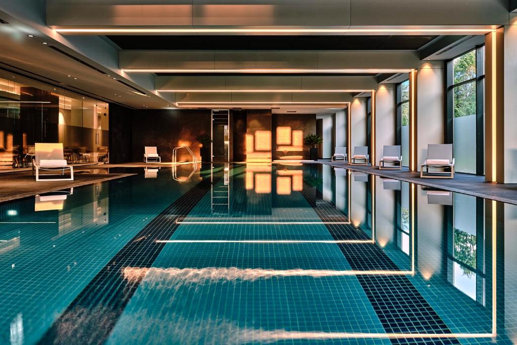 a swimming pool in a hotel with chairs at Crowne Plaza Sofia by IHG in Sofia
