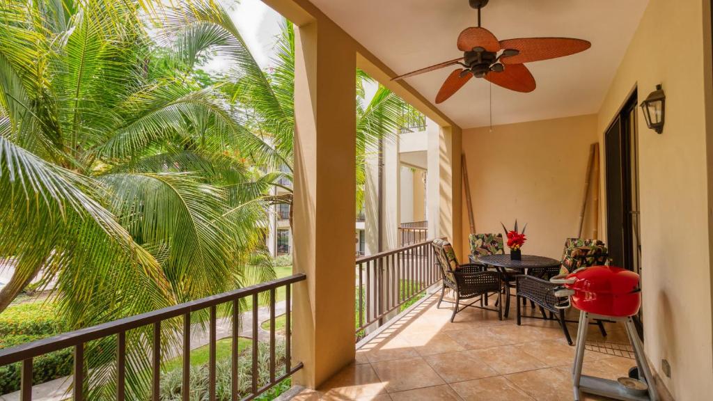 a balcony with a table and a ceiling fan at Spacious One-Bedroom Condo with Pool View, Balcony & Beach Club Access in Coco