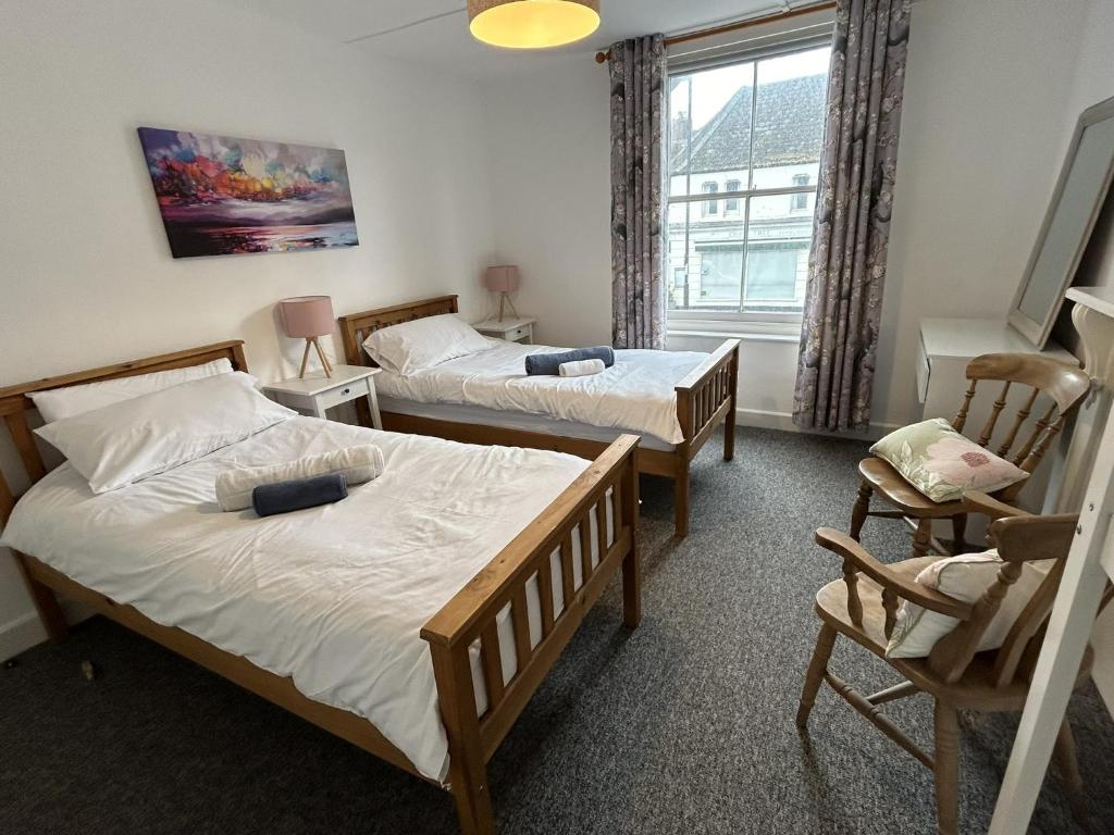 a bedroom with two beds and a window at Lord Nelson Hotel in Bridport