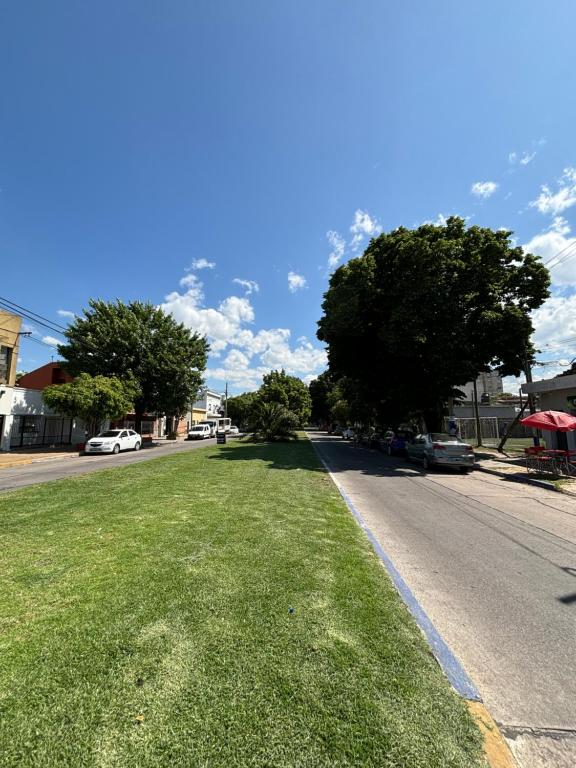 una calle con un campo de césped al lado de una carretera en Departamento 66 - cochera opcional -, en La Plata