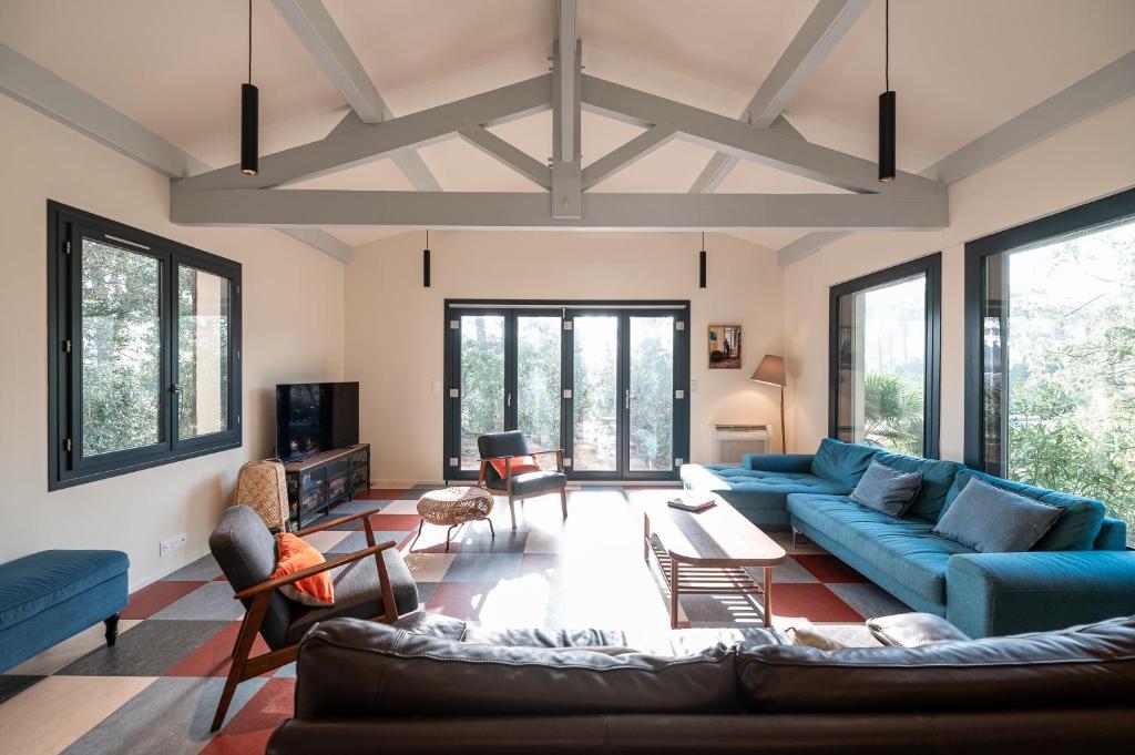 un salon avec un canapé bleu et des chaises dans l'établissement Villa COUDINEY, à Biscarrosse