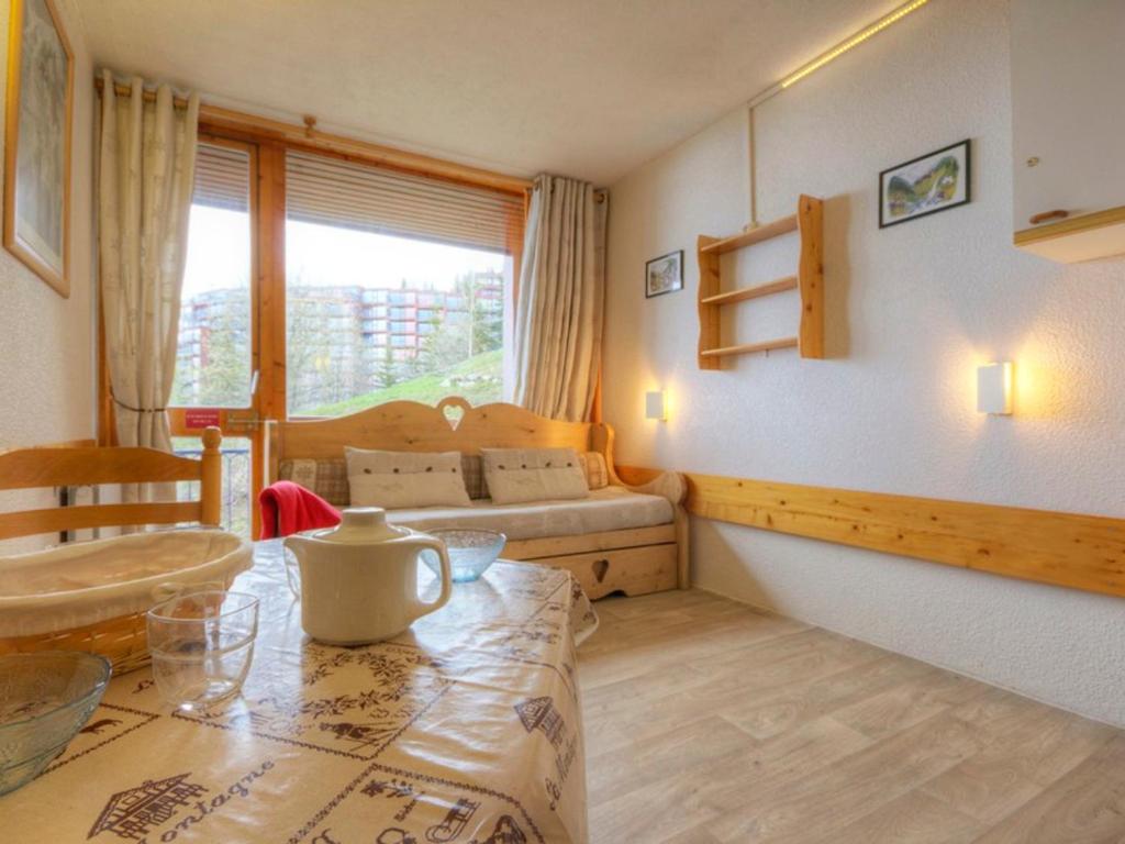 Cette chambre comprend une table, un lit et une fenêtre. dans l'établissement Studio cosy proche pistes, balcon, WIFI gratuit, parking à proximité - FR-1-346-473, à Arc 1800