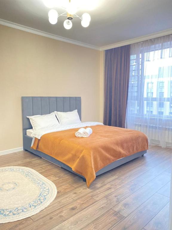 a bedroom with a bed and a large window at Б241 Нурлы-жол in Promyshlennyy